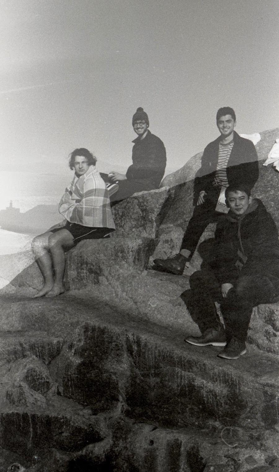 Students sitting on a rock after a swim